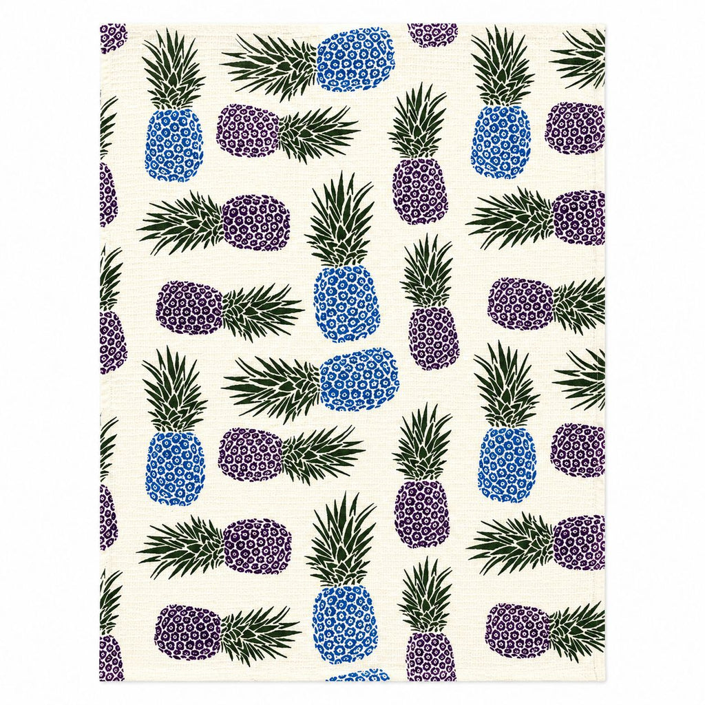Patterned fabric with blue, purple, and green pineapple design on a white background